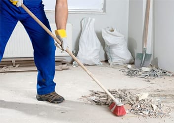 Post-construction cleanup with vacuum and debris removal from unfinished floor